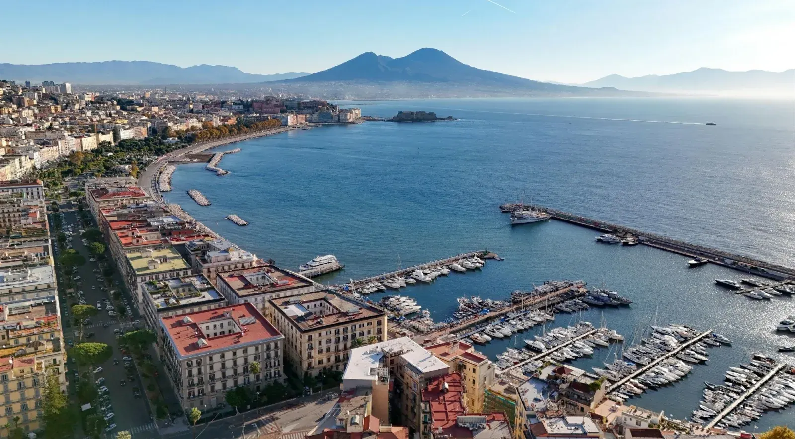 Aerial view of Naples harbour with Mount Vesuvius rising behind the bay on a clear sunny day